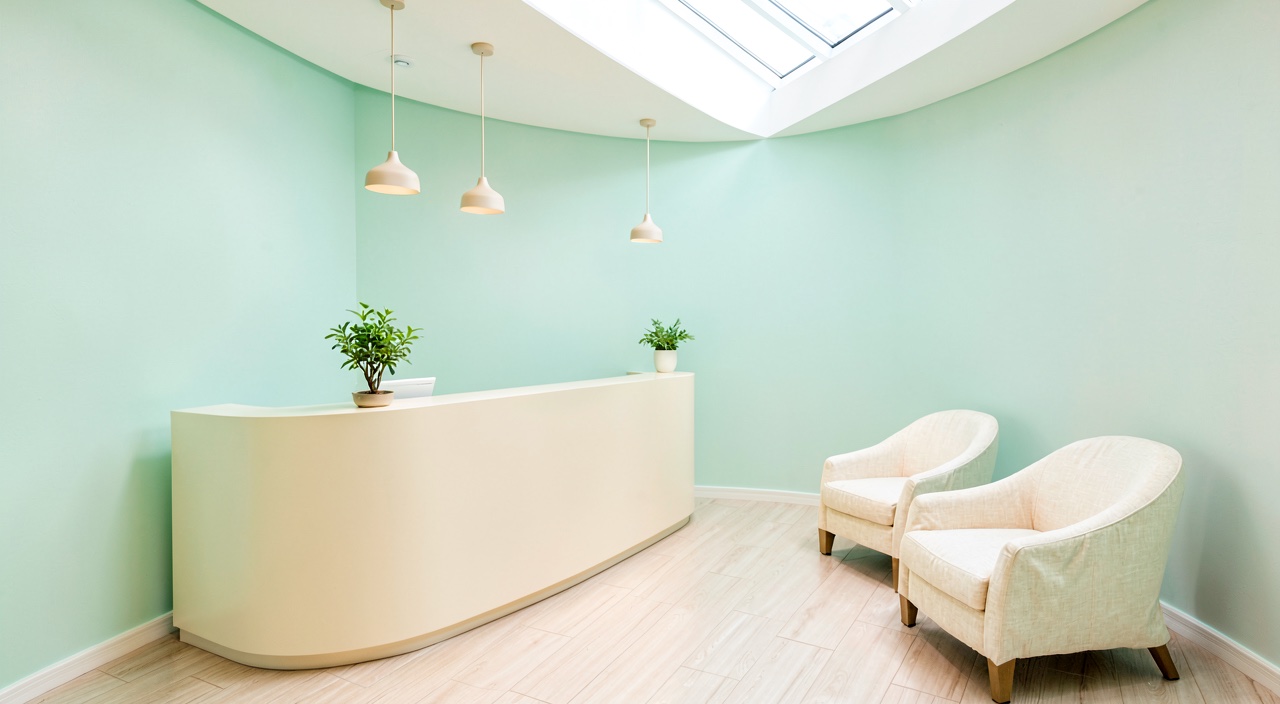 The reception area at Lumina Dental, with soft mint walls and natural light